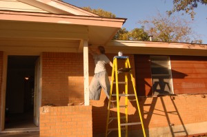 Rebekah Courter paints the exterior of the house.